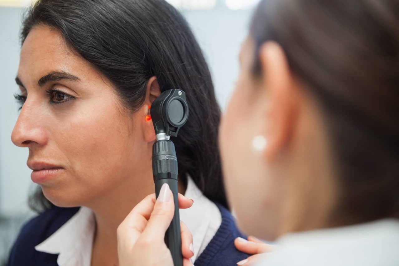 Photo of a provider using an otoscope to examine a patient