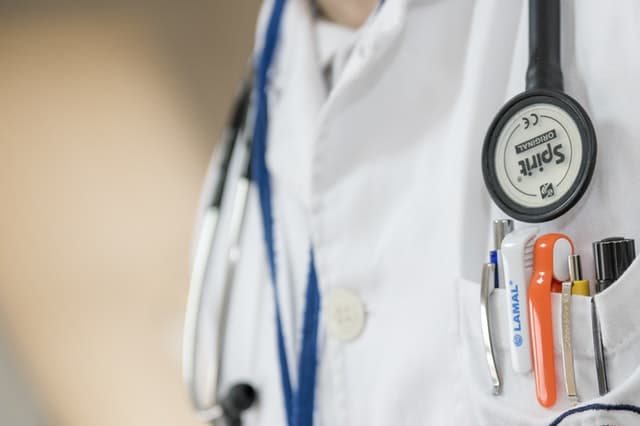 a doctor wearing their white coat and stethoscope