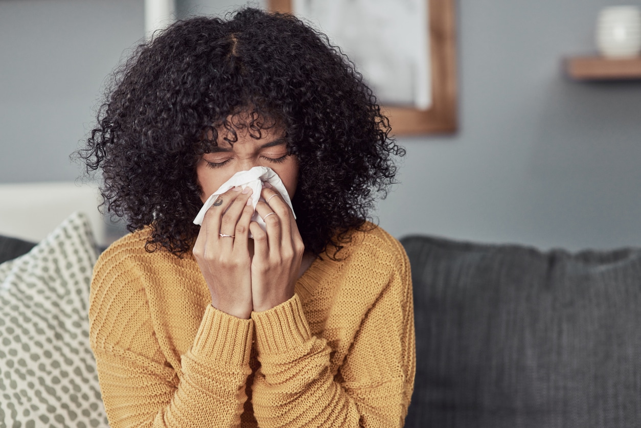 Woman with sinusitis blowing her nose.