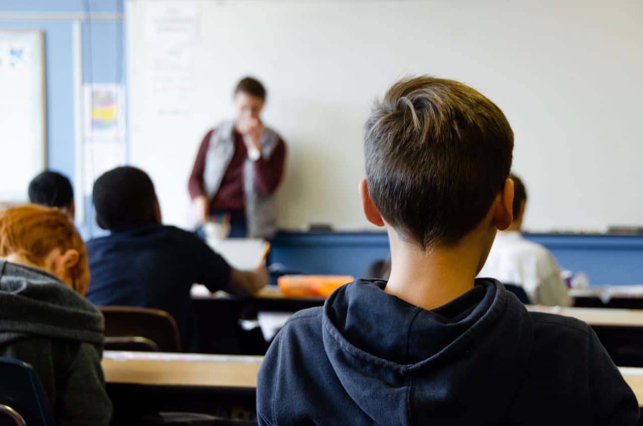 Children paying attention to a teacher in a classroom.