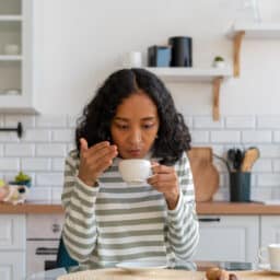 Woman having trouble smelling her morning cup of coffee.