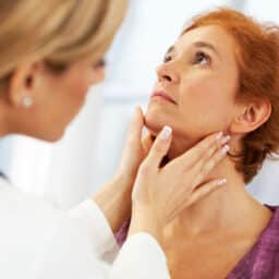 Doctor examines woman's neck